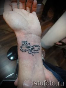 Фото тату бесконечности с именами 'Ellie' и 'Grace', выполненной на запястье. Минималистичный дизайн, символизирующий вечную любовь и связь.