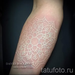 Фото тату: изящная белая мандала, нанесенная на руку, создающая эффект легкой тени и воздушности.