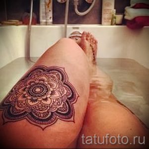 Фото татуировки мандалы на бедре, сделанное в ванной. Чёрно-серый рисунок с детальной проработкой узоров и элементов.