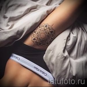 Фото татуировки мандалы на локтевом сгибе. Светлый, пастельный рисунок с тонкими линиями и точками, выполненный в минималистичном стиле.