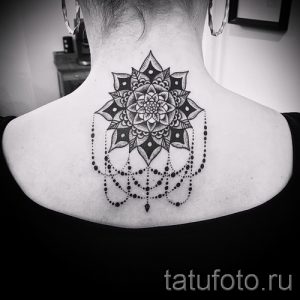 Фото тату мандалы на затылке. Черно-серая татуировка с детализированными узорами и подвесками. Изысканный рисунок татуировки.
