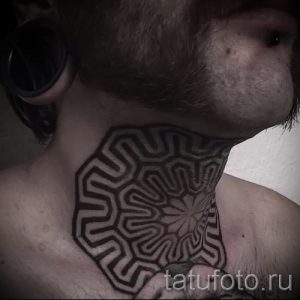 Фото тату: черно-белая геометрическая мандала на шее, выполненная в стиле минимализм. Сложный узор из линий и фигур.