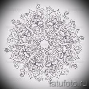 Черно-белый эскиз татуировки в стиле мехенди, изображающий сложную мандалу с множеством мелких деталей и растительных элементов. Идеально подходит для тех, кто ценит восточную культуру.