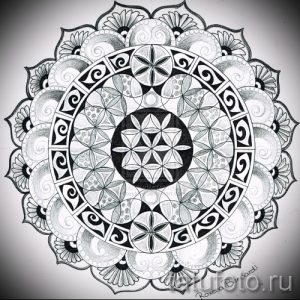 Черно-белое фото тату мандалы с геометрическими узорами и цветочными элементами. Детализированный рисунок татуировки, выполненный в технике дотворк.
