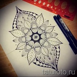 Фотография эскиза татуировки мандалы, выполненной в технике дотворк с использованием изображения листьев. Идеально для создания оригинальной тату на плече или предплечье.