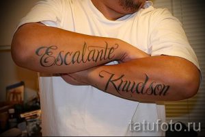 Фото тату: имена "Escalante" и "Kaudson" выполнены черным цветом на предплечьях. Имена написаны изящным шрифтом.