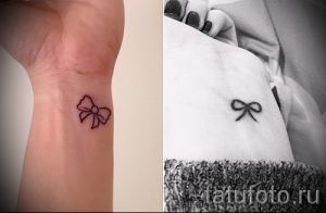 Фото тату маленького красного бантика на запястье девушки. Нежный рисунок татуировки, выполненный в минималистичном стиле.