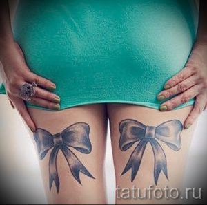 Фото тату двух серых бантиков, расположенных на бедрах. Изящный и стильный дизайн.