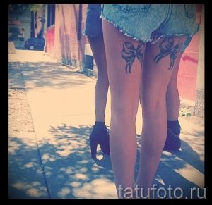 Фото тату: парные татуировки в виде черных бантиков на голенях. Элегантный рисунок татуировки создает романтичный образ.