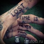 Фото тату на руках: надписи 'LOST TIME IS NEVER FOUND', выполненные в небрежном стиле. Черно-белые татуировки, имитирующие рукописный текст.