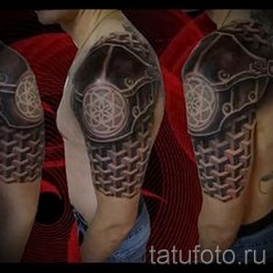 Фото тату: татуировка на плече, изображающая футуристическую броню с геометрическими узорами и сложной текстурой, выполненная в черно-серых тонах.