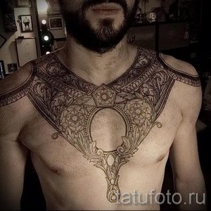 Фото тату кельтского узора на груди мужчины. Сложный орнамент с геометрическими формами и переплетениями, выполненный в черном цвете.