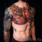 Фото тату: реалистичная татуировка на торсе мужчины в стиле биомеханика, с использованием ярких цветов и сложных механических элементов.