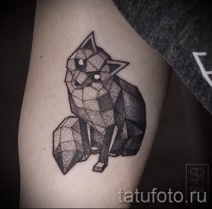 Фото тату лисы, выполненной в технике полигонального рисунка. Черно-белый рисунок татуировки выглядит стильно и необычно.