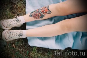 Фото тату лисы и розы на ноге, выполненное в ярких цветах. Изображение сочетает в себе реалистичные детали и элементы акварели.