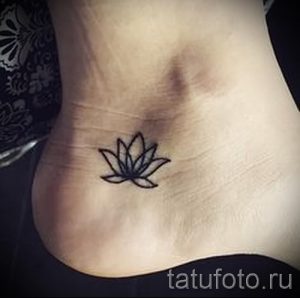 Фото тату: небольшая черно-серая татуировка лотоса на лодыжке, выполненная в минималистичном стиле. Простой и элегантный дизайн.