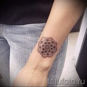 Фото тату: Небольшая коричневая мандала на внутренней стороне запястья. Детализированный рисунок татуировки в стиле дотворк.