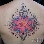 цветная мандала и цветок в женской тату на спину