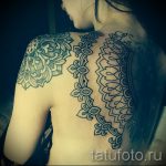 Фото тату: Симметричная татуировка мандалы, разделенная на две части, расположенная на спине. Детализированный рисунок в графическом стиле.