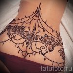 Фото татуировки хной на женской спине и ягодицах. Сложный узор с использованием растительных мотивов и геометрических фигур.