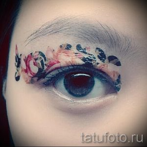 Фото тату: акварельный рисунок на веке глаза, имитирующий макияж. Яркие цвета и плавные переходы создают эффектный образ.