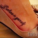 Фото тату: черная надпись "Believe in yourself" (верь в себя) на женской лодыжке, выполненная каллиграфическим шрифтом.
