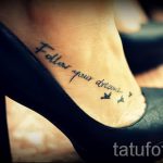 Фото тату: Черная надпись "Follow your dreams" на лодыжке с небольшими бабочками. Простой и вдохновляющий дизайн.