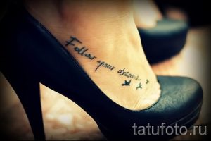 Фото тату: Черная надпись "Follow your dreams" на лодыжке с небольшими бабочками. Простой и вдохновляющий дизайн.