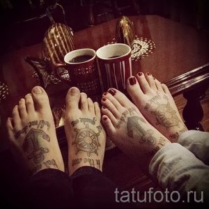 Фото тату: парные татуировки на стопах с изображением якоря, руля и морских узоров. Классический морской стиль.