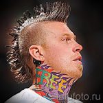 Фото тату надписи 'FREE' на шее мужчины с ирокезом. Яркие цвета, граффити стиль, динамичный образ.
