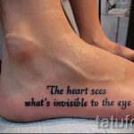 Фото тату надписи 'The heart sees what's invisible to the eye' на женской стопе. Надпись выполнена черным цветом, простым шрифтом.