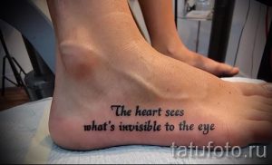 Фото тату надписи 'The heart sees what's invisible to the eye' на женской стопе. Надпись выполнена черным цветом, простым шрифтом.