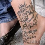 Фото тату длинной молитвы на женской стопе. Текст выполнен черным цветом, в стиле графика, с использованием различных шрифтов и размеров.