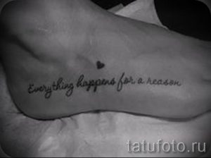 Фотография татуировки на стопе с надписью 'Everything happens for a reason' и маленьким сердечком, выполненных черными чернилами.