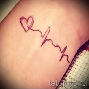 Фото тату на запястье: Тонкая линия электрокардиограммы, переходящая в контур сердца. Простой и элегантный рисунок татуировки.