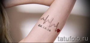 Фото минималистичной татуировки на предплечье: линия пульса, сердце и дата '22.12.12'. Тонкие линии, лаконичный дизайн, личный смысл.