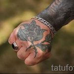 Минималистичная татуировка на руке, изображающая черную розу с листьями. Простой и элегантный рисунок татуировки.