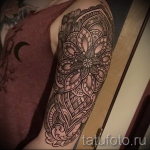 Фото тату: детальная мандала на плече, выполненная в технике дотворк с использованием тонких линий и градиентов.