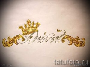 Фото тату: эскиз татуировки с именем 'Daniel', украшенным золотой короной и витиеватыми узорами в стиле каллиграфии.