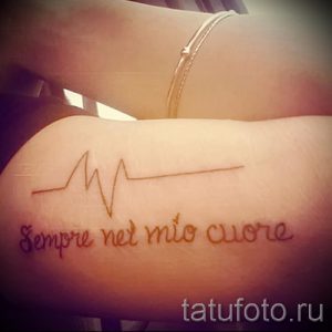 Фото тату: татуировка на руке, изображающая линию кардиограммы и фразу 'Sempre nel mio cuore' на итальянском языке.
