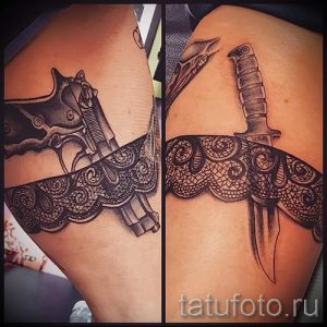 Фото тату: необычная татуировка на бедре, сочетающая в себе изображение пистолета и ножа с ажурным кружевом. Рисунок выполнен в черно-белой гамме.