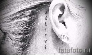Фото тату: вертикальная надпись 'BELIEVE' на затылке, выполненная черным цветом. Мотивационная и стильная татуировка.