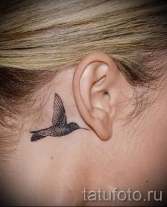 Фото тату: маленькая татуировка колибри на затылке, выполненная в технике blackwork. Изящный и минималистичный рисунок.