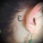 Фото тату полумесяца и звезд на шее возле уха. Черно-белый рисунок татуировки, выполненный тонкими линиями.