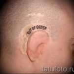 Фото тату: Оригинальная татуировка с надписью 'Out of Order' в виде таблички, расположенная на затылке. Юмористический и провокационный рисунок.