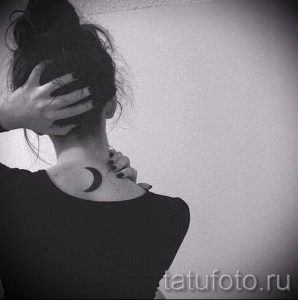 Фото тату: Изящная черная татуировка в виде полумесяца, расположенная на затылке девушки. Минималистичный дизайн.