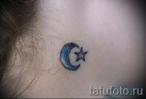 Фото небольшой татуировки с изображением синей луны и звезды. Минималистичный рисунок татуировки на шее.