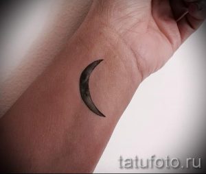 Фото тату: небольшой полумесяц на запястье, выполненный в технике blackwork. Минималистичный рисунок татуировки.