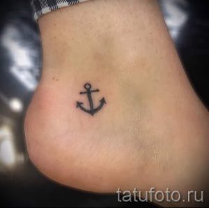 Фото маленькой татуировки якоря на лодыжке. Простой и лаконичный рисунок в черном цвете.
