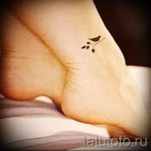 Фото маленькой татуировки птички на лодыжке. Изящный рисунок с тонкими линиями, выполненный в минималистичном стиле.